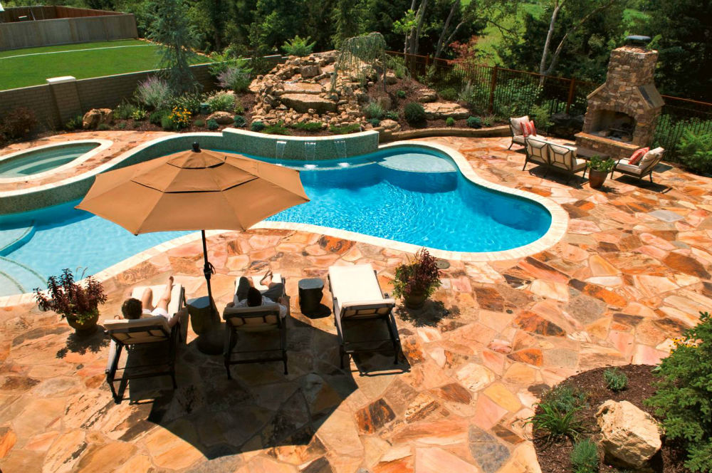 Stone pool patio landscaping with waterfall