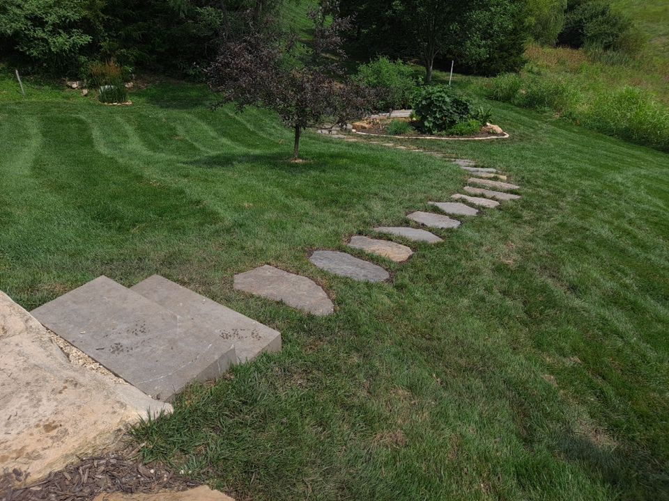 stone pathway leading through a landscaped yard