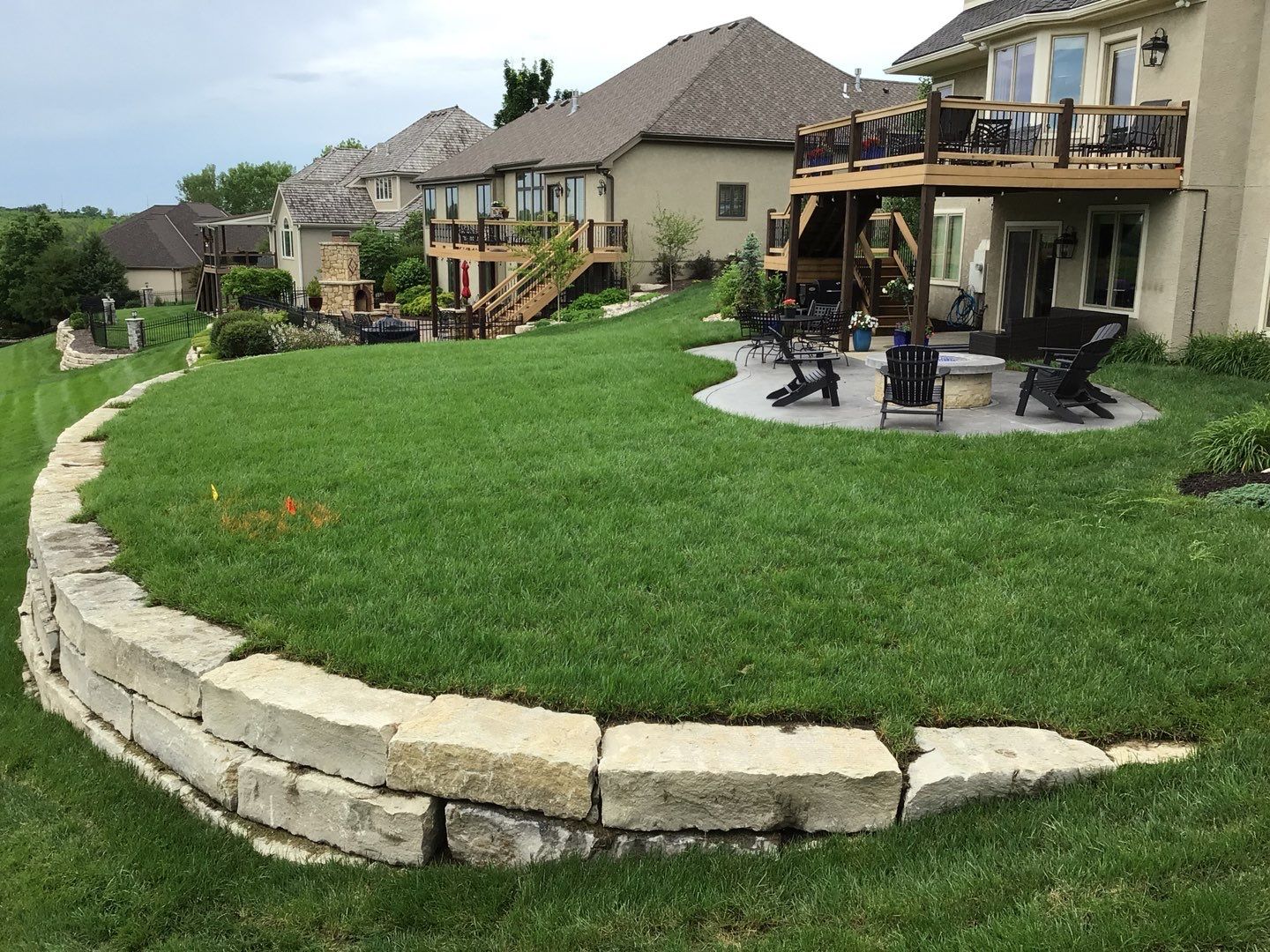 retaining wall in backyard of home along with patio and fire pit
